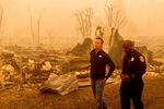 California Gov. Gavin Newsom surveys Greenville homes leveled by the Dixie Fire on Saturday, Aug. 7, 2021, in Plumas County, Calif. Accompanying him is Cal Fire Assistant Region Chief Curtis Brown.