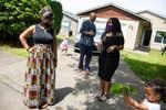 LaTasha Taylor, second from right, talks to friends in the driveway of her new home Friday, June 19, 2020, in Portland, Ore. Friends held a drive-up Juneteenth celebration and housewarming for Taylor and her family.