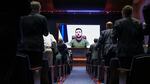 Members of Congress give a standing ovation to Ukrainian President Volodymyr Zelenskyy as he appears via video, projected on a large screen.
