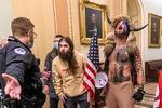FILE - Supporters of President Donald Trump, including Jacob Chansley, right with fur hat, are confronted by U.S. Capitol Police officers outside the Senate chamber inside the Capitol during the capitol riot in Washington, Jan. 6, 2021. Chansley was sentenced on Wednesday, Nov. 17, 2021, to 41 months in prison for his felony conviction for obstructing an official proceeding. Though he wasn't accused of violence, Chansley acknowledged he was among the first 30 rioters in the building, offered thanks while in the Senate for having the chance to get rid of traitors and wrote a threatening note to Vice President Mike Pence.