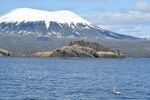 A mini boat sails in front of Mt. Edgecumbe in Alaska's Sitka Sound.
