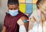 In this 2022 photo, a health care provider places a bandage on the injection site of a patient who just received an influenza vaccine. The best way to prevent seasonal flu is to get vaccinated every year. 
