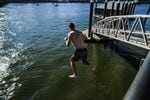 A man jumps into the Willamette River in Portland. City officials expect more people to take to the water this summer.