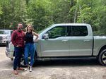 Schmidt and his wife pose with their new F-150 Lightning.