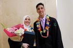 Graduating seniors Salma Bashir and Ahmed Al-Dulaimi pose for photographs after receiving their diplomas.
