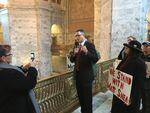 Republican state Rep. Matt Shea records a video on the first day of the legislative session while a small group of supporters gather around him.