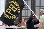 FILE - In this Sept. 7, 2020, file photo, a protester carries a Proud Boys banner, a right-wing group, while other members start to unfurl a large U.S. flag in front of the Oregon State Capitol in Salem, Ore.  The Canadian government designated the Proud Boys group as a terrorist entity on Wednesday, Feb. 3, 2021, noting they played a pivotal role in the insurrection at the U.S. Capitol on Jan. 6.  