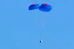 Parachutes slow the descent of the Blue Origin capsule with passengers William Shatner, Chris Boshuizen, Audrey Powers and Glen de Vries near the company's spaceport near Van Horn, Texas.