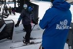 Two people board a chair lift at Mt. Bachelor ski resort outside Bend, Ore., Monday, Dec. 7, 2020. Mt. Bachelor opened its winter ski season with new restrictions to limit the spread of coronavirus.