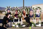Two people put up a memorial with photographs of the five victims of a weekend mass shooting at a nearby gay nightclub on Tuesday, Nov. 22, 2022, in Colorado Springs, Colo.