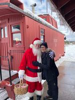 Oregon Field Guide reporter Jule Gilfillan gets a hug from a very real Santa Claus at the Christmas train in Sumpter, Ore.