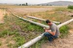 Justin Grant opens an irrigation pipe that allows water from his agriculture well to move into nearby cattle grazing fields, Saturday, July 24, 2021, in Klamath Falls, Ore. Dozens of domestic wells have gone dry in an area near the Oregon-California border where the American West's worsening drought has taken a particularly dramatic toll. 