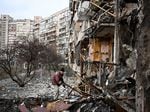A man clears debris at a damaged residential building in Kyiv in February, just after Russia started its invasion.