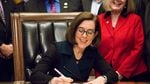 Oregon Gov. Kate Brown signs a bill into law to increase the state minimum wage in March 2016.