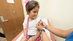 A young child gets a band aid after getting a vaccine.