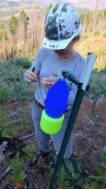 Sydney Watkins checks a blue vein trap for native bees on BLM land.