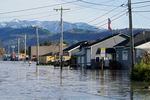 Floodwater inundates homes along a road Wednesday, Nov. 17, 2021, in Sumas, Wash. An atmospheric river—a huge plume of moisture extending over the Pacific and into Washington and Oregon—caused heavy rainfall in recent days, bringing major flooding in the area. (AP Photo/Elaine Thompson)