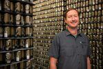 Dustin Kellner, director of brewery operations for Worthy Brewing, poses for a portrait amid cans that will soon be filled with the brewery's Lights Out stout, in Bend, Oregon, September 20, 2022.