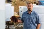 Dulse harvester James Weimar holds a near-mature dulse frond next to his sea water tanks on the Port of Port Orford dock, June 13, 2018.