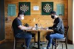 Colin Rath, right, one of the owners of Migration Brewing, sits with operations  manager Brandon Mikel. Rath said he is frustrated Gov. Kate Brown may impose new dining restrictions. “It’s a whole lot of a guessing game," Rath said. "Staff don’t know what to plan on. Guests don’t know what to plan on.”