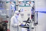 A photo from November 2021 shows employees in cleanroom "bunny suits" working at Intel's D1X factory in Hillsboro, Ore. 