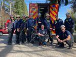Portland firefighters pose with Tess, the Labrador, shortly after rescuing her from a manhole in Portland, Ore., on March 17, 2023.