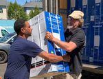 A delivery of 80 air conditioning units is unloaded at the Portland Open Bible Community Pantry in Southeast Portland on Monday, July 25. The units were purchased by the Oregon Health Authority with a $5 million allocation from the Legislature.