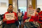 Members of the Leaven Community Land & Housing Coalition attend a Portland City Council meeting on Thursday, Nov. 3, 2022, in Portland, Ore., to oppose a resolution that would ban street camping and create designated areas for homeless camping.  The resolution sparked a heated debate in the city.