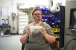 Evelyn Verzwyvelt, design for manufacturing lead at Sigma Design in Camas, Washington, holds up an assembled face shield prior to sanitizing, April 6, 2020.