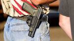 Around a man's belt is a gun in a holster.