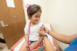 A young child gets a band aid after getting a vaccine.