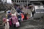 Dozens of people flee a Ukrainian town on foot as the conflict with Russia persists.