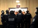 Police block an entryway to the Oregon Capitol as protesters attempt to gain access.