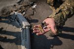 March 25: A member of the Territorial Defense Units shows the camera shrapnel from a missile on the outskirts of the city of kyiv, Ukraine.