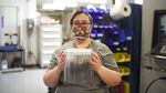 Evelyn Verzwyvelt, design for manufacturing lead at Sigma Design in Camas, Washington, holds up an assembled face shield prior to sanitizing, April 6, 2020.