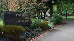 A sign reads "Portland State University," next to a sidewalk that runs through a lawn with trees and other plant life.