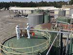 Two EPA employees confer while standing on J.H. Baxter's tank farm in Eugene.