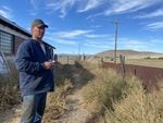 A farmer looks out at his field at daytime.