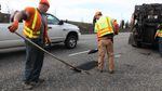 An Oregon Department of Transportation crew fills potholes on Highway 26 in this April 14, 2017, file photo.