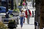Residents wearing masks walk in downtown Lake Oswego, Ore., on Sunday, April 11, 2021.