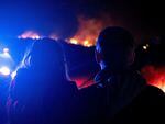 Dr. Bonnie Abbott (L) embraces her husband George as they watch flames engulf homes as the Marshall Fire spreads through a neighborhood in the town of Superior in Boulder County, Colorado on Dec. 30, 2021.