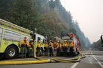 Fire crews from different parts of the state rest at the bottom of Multnomah Falls where they worked to prevent the Multnomah Falls Lodge from burning on Sept. 6, 2017.