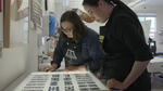 Master printer Judith Baumann and artist Wendy Red Star work on a print in the printmaking studio at Crow's Shadow, 2022.