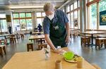 Volunteer Jim Jackson of Portland cleans tables on May 2, 2022, as Blanchet House reopened for indoor dining following more than two years of closure due to the pandemic.