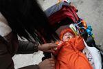 Tatyana Polishchuk tends to her baby, wrapped in warm clothes in a stroller on a walk in Kyiv.