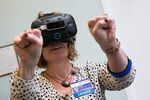 Clinic supervisor Mary Hlady collected virtual fireflies in her hands during a VR for pain management demo at Providence Gresham Rehab and Sports Therapy clinic.   