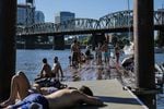 Swimmers gather on a dock on the Willamette River in Portland.