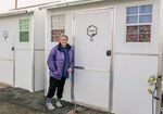 Kathryn Perkins poses outside a tiny home she lives in at a non-congregate homeless shelter located in The Dalles on December 13, 2022. Perkins, who is currently experiencing homelessness, has lived at the shelter for six months with her dog, Monster, while trying to transition to permanent housing.