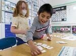 FILE: Emmet Lopez-Hunt, left, and Jonathan Cordova work together to sort flashcards during a reading lesson in Coral Walker’s first grade class at Lent K-8 in Southeast Portland, March 29, 2022.