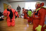 Students drill putting on an immersion suit. Getting into one before getting wet can give someone a much better chance of survival. A suit should keep its occupant warm for hours.